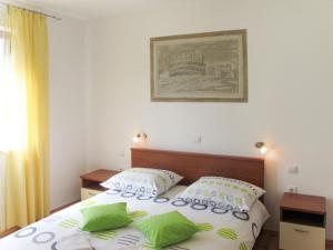 a bedroom with a bed with green and white pillows at Apartment Banko - PUL408 by Interhome in Peroj