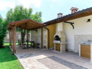 an outdoor patio with a fireplace and awning at Holiday Home Verbanac - LBN351 by Interhome in Labin