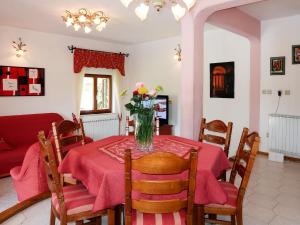 a dining room table with a vase of flowers on it at Apartment Ornela - LBN321 by Interhome in Nedeščina