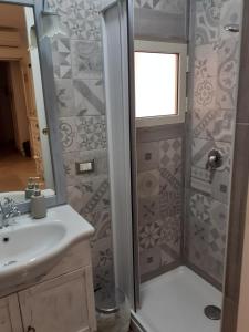 uma casa de banho com um chuveiro e um lavatório. em Il Vicoletto em Santa Marinella