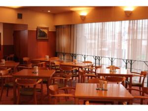 uma sala de jantar com mesas e cadeiras de madeira em Mizusawa Ground Hotel - Vacation STAY 85019 em Oshu