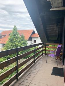 Komenda的住宿－Ela's Apartment，坐在房子阳台上的紫色椅子