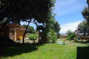 einen Hof mit einer Schaukel und einem Spielplatz in der Unterkunft Ô chalets de Provence in Suze-la-Rousse