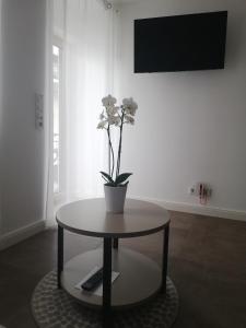 a table with a vase with flowers on top of it at Ferienwohnung Riesling in Lieser