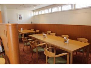 une salle à manger avec des tables et des chaises en bois dans l'établissement Mizusawa Ground Hotel - Vacation STAY 84945, à Oshu