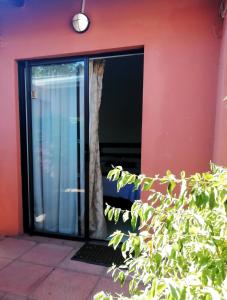 a glass door of a red building with a window at Mashusha Bed & Breakfast in Gaborone