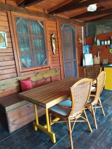 una mesa de madera y sillas en una cabaña en Holiday Home Bojanka, en Ulcinj