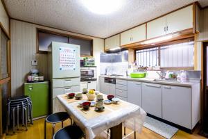 een keuken met een tafel en een groene koelkast bij Asahi - Vacation STAY 84795 in Fujiyoshida