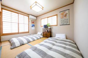 drie bedden in een kamer met ramen bij Asahi - Vacation STAY 84795 in Fujiyoshida