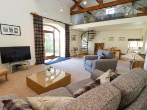 a living room with a couch and a tv at The Barn in Harrogate