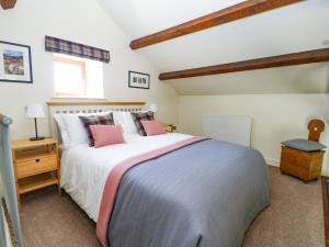 ein Schlafzimmer mit einem großen Bett und einem Fenster in der Unterkunft The Barn in Harrogate
