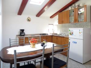 cocina con mesa y nevera blanca en Apartment Johan - MOD117 by Interhome, en Brseč