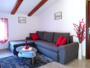 uma sala de estar com um sofá cinzento e almofadas vermelhas em Apartment Johan - MOD117 by Interhome em Brseč