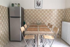 tavolo e sedie in cucina con frigorifero di Le Girandole a Como