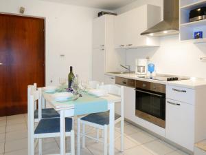 a kitchen with a table and chairs with a bottle of wine at Apartment Jurkovic - NJI101 by Interhome in Njivice