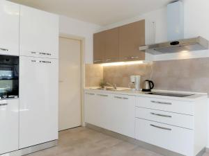 a kitchen with white cabinets and a sink at Apartment Jurkovic - NJI100 by Interhome in Njivice