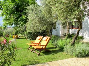 tre sedie arancioni sedute sull'erba in un cortile di Apartment Jurkovic - NJI100 by Interhome a Njivice