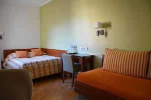 a hotel room with a bed and a desk and a chair at Preliudija in Klaipėda