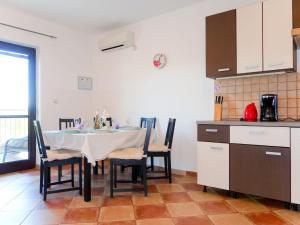 - une cuisine avec une table et des chaises dans la chambre dans l'établissement Apartment Urdih - KRK316 by Interhome, à Malinska