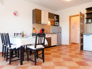 a kitchen with a table and chairs in a room at Apartment Urdih-2 by Interhome in Malinska