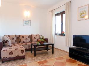 - un salon avec un canapé et une télévision dans l'établissement Apartment Urdih - KRK316 by Interhome, à Malinska