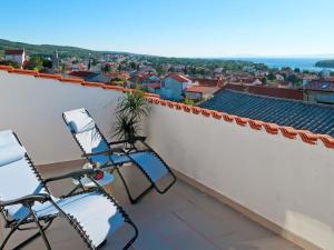 two chairs on a balcony with a view of a city at Apartment Barbara - PUT121 by Interhome in Punat
