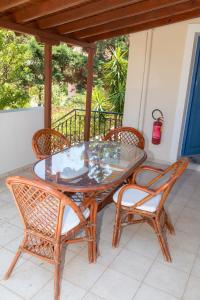 una mesa de cristal y sillas en un patio en Fereniki Studios, en Plati