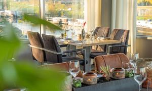 een eetkamer met een tafel en stoelen en een raam bij Gastenverblijf 't Smedenhuys in Maasbracht