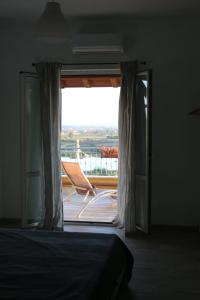 a bedroom with a bed and a window with a chair at Belvedere Sasso in Sasso