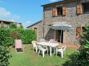 a table and chairs with an umbrella in a yard at Holiday Home Boriano-4 by Interhome in Lubriano