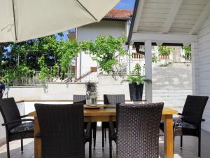 drewniany stół z krzesłami i parasol na patio w obiekcie Holiday Home Dada - BIG316 by Interhome w mieście Sveti Filip i Jakov