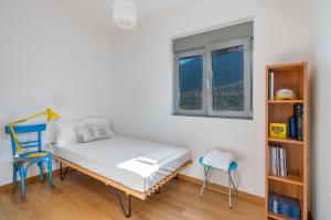 a bedroom with a bed and a chair and a window at Your Home2b in Paianía