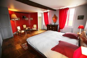 a bedroom with a large bed and red walls at Chambres d'Hôtes Le Mas in Aire-sur-lʼAdour