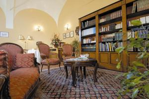 sala de estar con mesa, sillas y estante para libros en La Locanda Di San Francesco, en Montepulciano