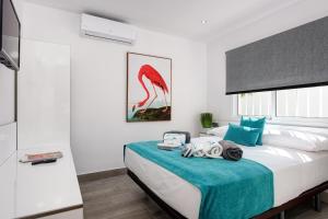 a bedroom with a large bed with a blue blanket at Villa El Ranchito By Seric, 15' walking to the beach in Torremolinos +28 photos