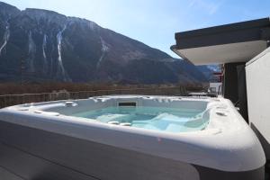 a hot tub on a balcony with a mountain at BnB Vino Veritas in Salgesch