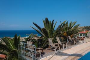 una fila de sillas sentadas en una terraza junto al océano en Villa Pasifai, en Mourteri