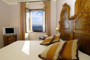 una camera da letto con un grande letto e una finestra di La Locanda Di San Francesco a Montepulciano