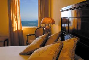 een slaapkamer met een bed met kussens en een raam bij La Locanda Di San Francesco in Montepulciano