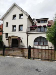 una casa blanca con una valla delante en Willa IDYLLA, en Kołobrzeg