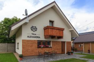 a villa with a balcony and a table at Villa Alexandra in Bešeňová