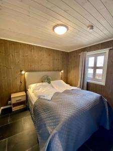 ein Schlafzimmer mit einem Bett in einem Zimmer mit einem Fenster in der Unterkunft Korgfjellet Fjellstue as in Korgen
