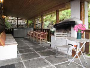 a patio with a grill and chairs and a table at Chalet Julie by Interhome in Eikelandsosen