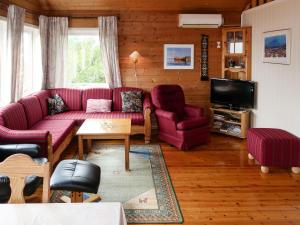 ein Wohnzimmer mit roten Sofas und einem TV in der Unterkunft Holiday Home Oasen - FJS143 by Interhome in Sørbø