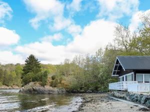 a house on the banks of a river at Holiday Home Jokobu - FJH087 by Interhome in Skånevik