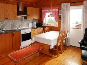 eine Küche mit einem Tisch und einem weißen Tischtuch in der Unterkunft Holiday Home Oasen - FJS143 by Interhome in Sørbø