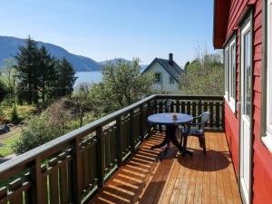 einen Tisch auf einem Balkon mit Blick auf das Wasser in der Unterkunft Holiday Home Oasen - FJS143 by Interhome in Sørbø