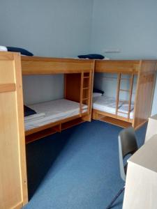 two bunk beds in a room with a chair at FSC Preston Montford Hostel in Shrewsbury