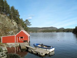 a boat docked at a dock next to a red building at Holiday Home Bjørkeneset - FJH621 by Interhome in Uggdal