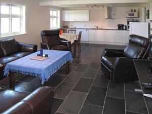 a living room with leather furniture and a table at Apartment Galanten by Interhome in Lunde